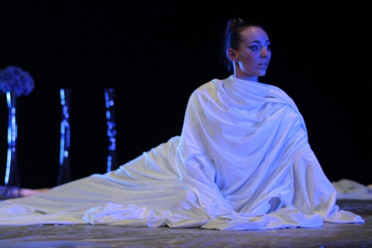 Photo d'une danseuse revêtant un drap blanc, prise lors d'une représentation de Nerell, la dame de givre. Une création origianel de la Cie Mouvementé Danse.