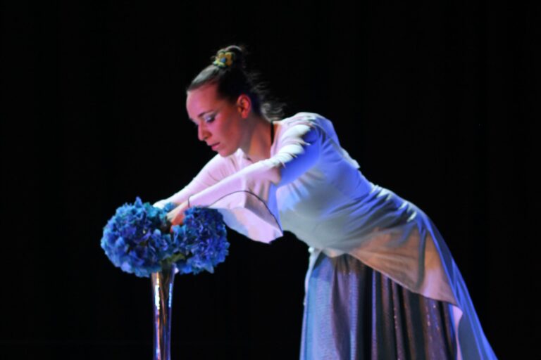 Photo zoomée sur le visage d'une danseuse tout de bleu vêtue, prise lors d'une représentation de Nerell, la dame de givre. Une création origianel de la Cie Mouvementé Danse.