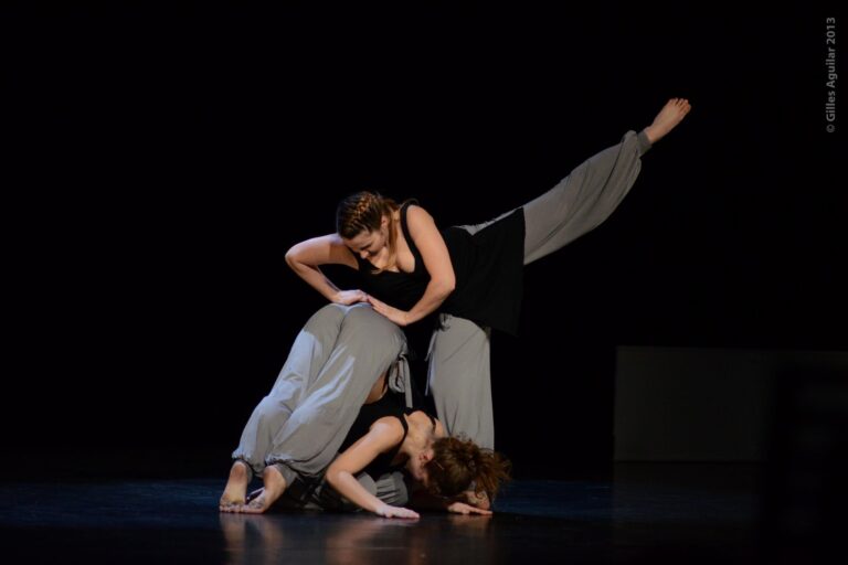 Photo de trois danseuses entrain de réaliser une figure technique, prise lors d'une représentation de White Noise Une création origianel de la Cie Mouvementé Danse.